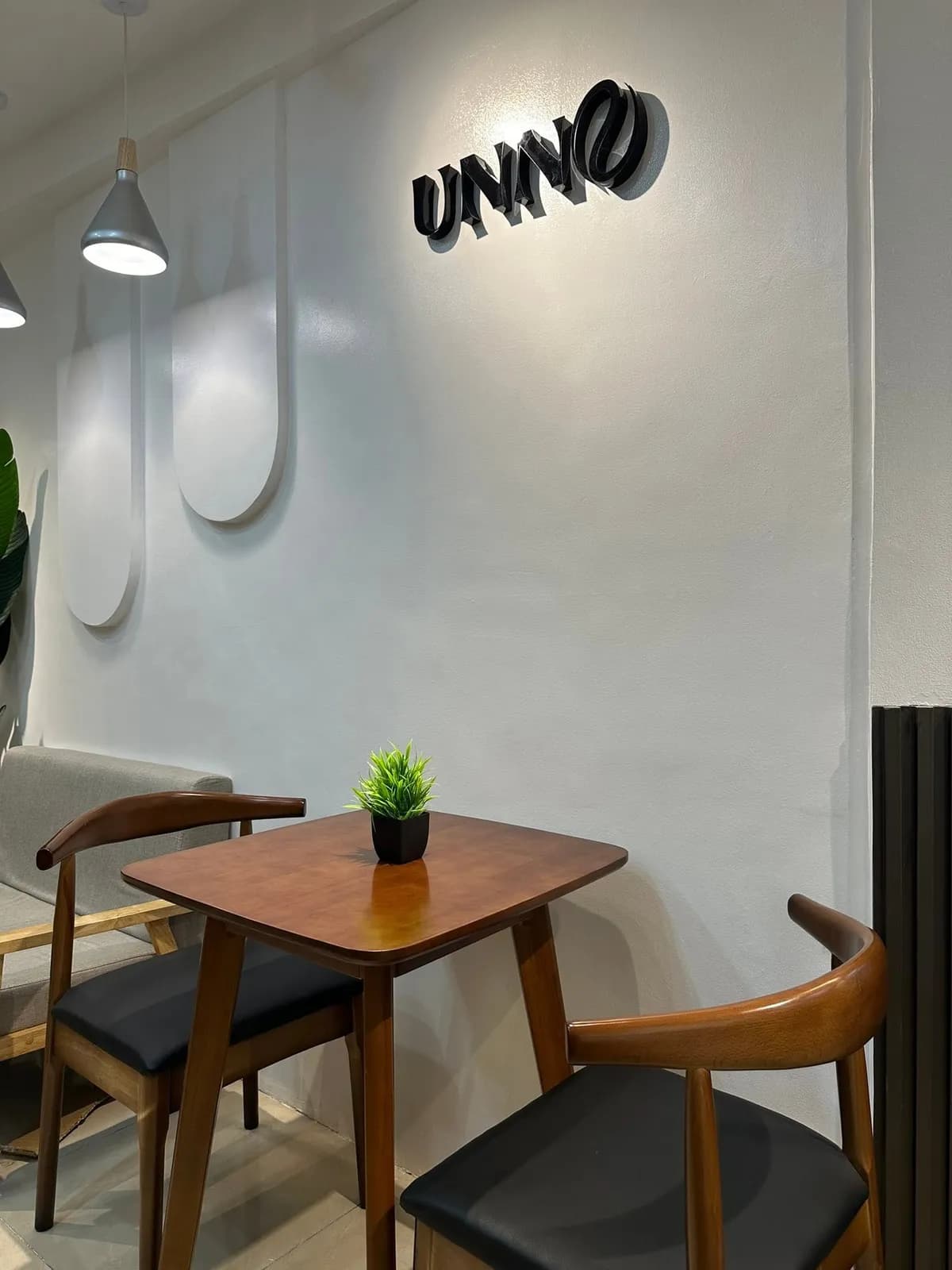 A corner of the Unno café with walnut chairs and the Unno wall sign